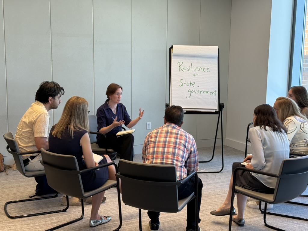 At InnSure's Insurability Planning workshop in Boston (2025), a group of seven people in a circle discuss "Resilience in State Government"